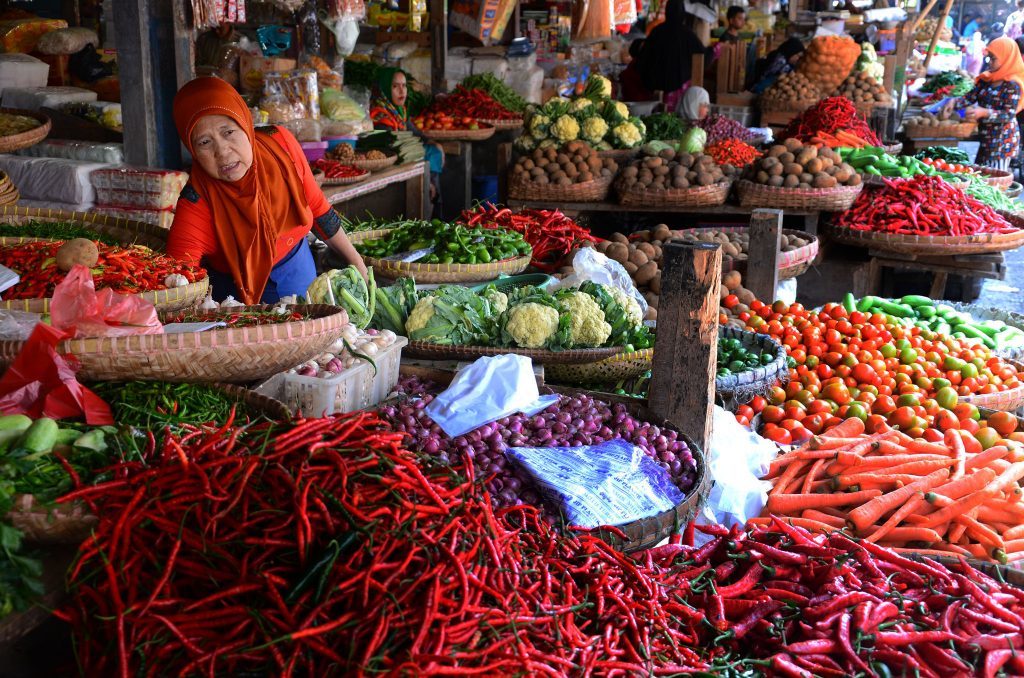 pedagang sayuran melayani pembeli pasar tradisional